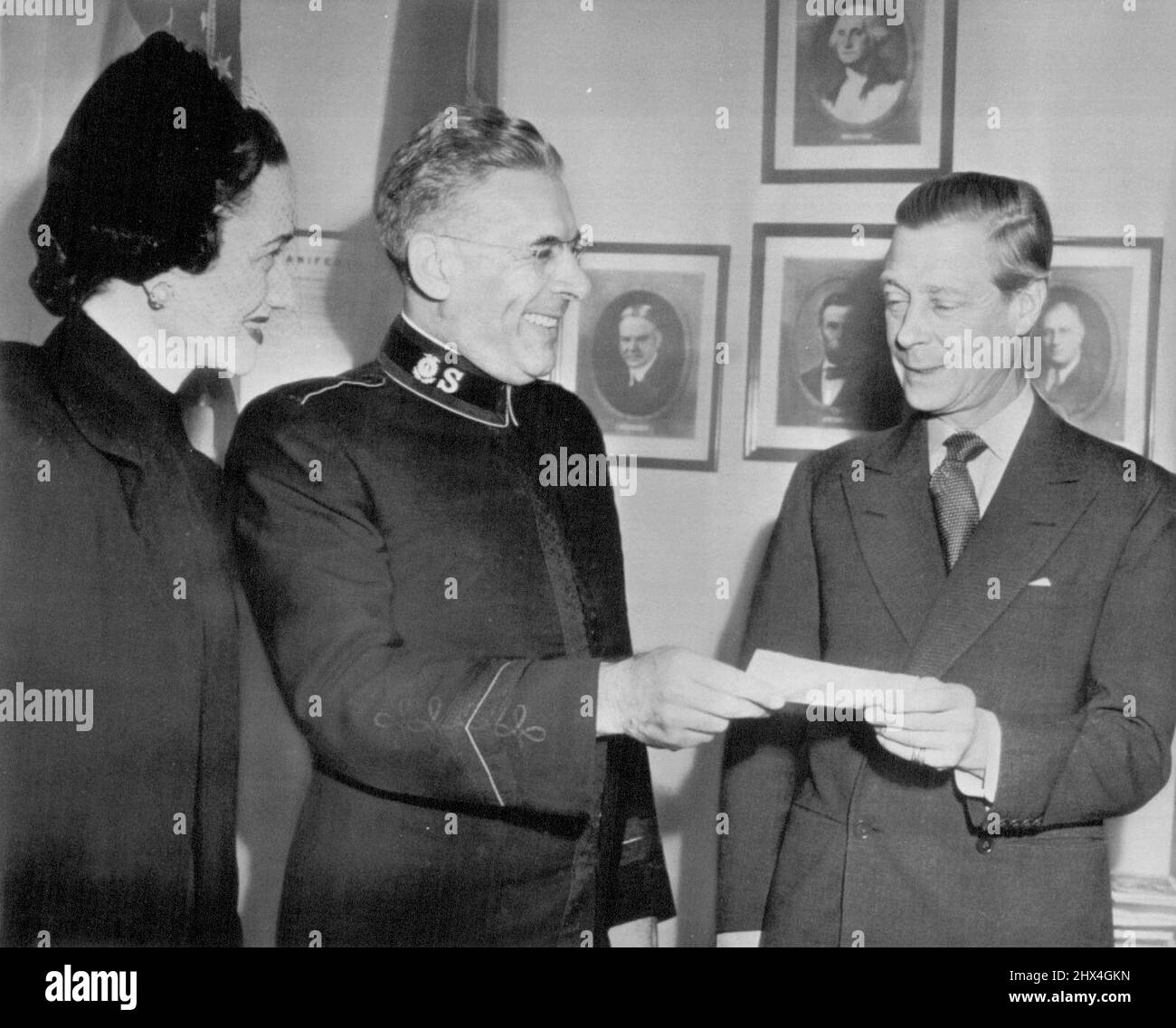 Duke of Windsor makes contribution -- The Duke of Windsor (right) presents a check to Commissioner Ernest I. Pugmire, National Commander of the Salvation Army, as the Duchess of Windsor (left) looks on here yesterday. The check marked the Duke and Duchess of Windsor's contribution to the Salvation Army's 1947 Annual Maintenance Appeal. December 10, 1946. (Photo by AP Wirephoto). Stock Photo
