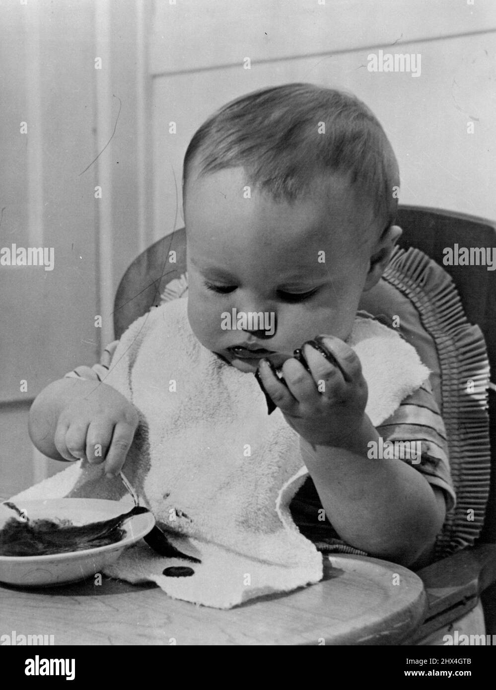 Prune Face -- Whatever you may think, baby-doctors, to a man, insist that prunes are a necessary part of a child's diet. April 14, 1952. (Photo by Look Magazine). Stock Photo