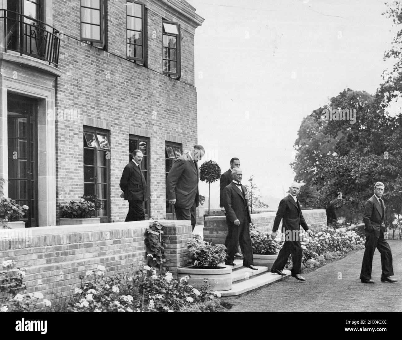 The King At The King's House. His Majesty Paid His First Visit to the King's House, the Royal Warrant Holders, Silver Jubilee Gift to King George V. Walton - On- Thames, Surrey, On a Beautiful woodland site Presented by Lord Iveagh.  4. H.M. The King leaving after the inspection of the house with members of the Committer. July 07, 1936. Stock Photo