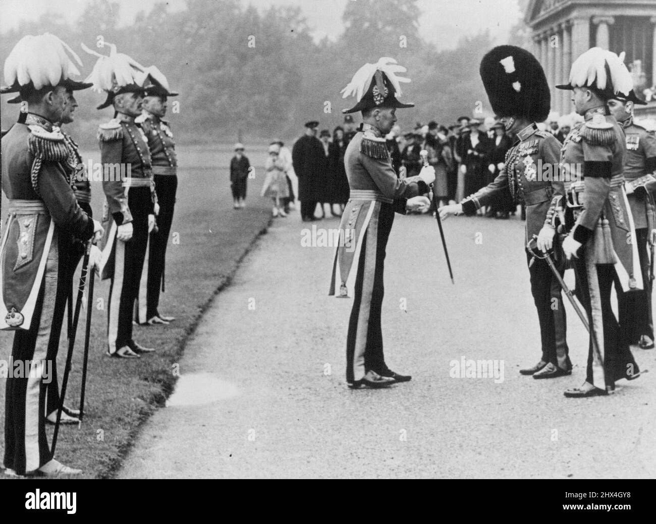 Official Photograph. H.M. The King Inspects the Yeomen of the Guard in the Grounds of Buckingham Place. This is the first time for many Years that the Reigning monarch has inspected this ancient body of men. H.M. the King Presenting the sticks of office of the officers of the King's Bodyguard of the Yeomen of the Guard in the grounds of Buckingham palace. The Royal Cypher on the Sticks has been altered from ' George V' to 'Edward VIII'. June 26, 1936. (Photo by Sport & General Press Agency, Limited). Stock Photo