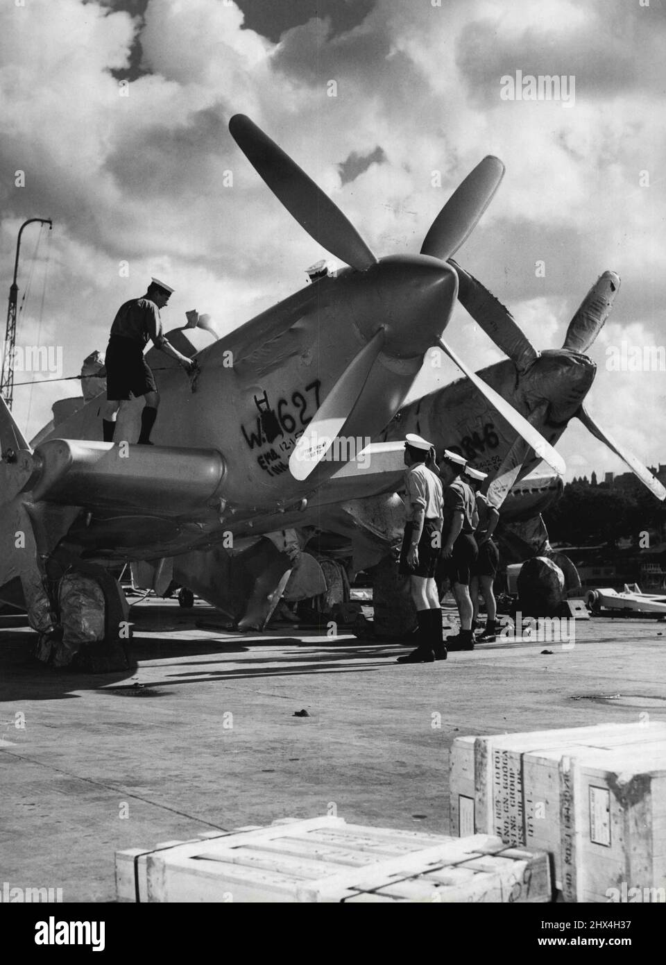 Aircraft handling crew of the carrier 'Vengeance' preparing to unloading planes from two flights deck along garden Is. March 12, 1953. (Photo by Winton Irving/Fairfax Media). Stock Photo