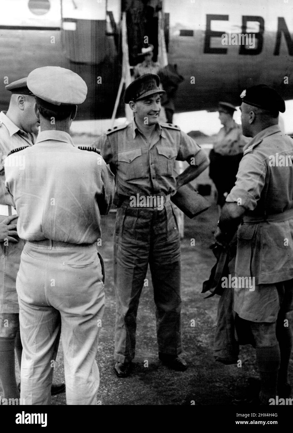 Public Relations Section. HQ BCOF. Japan -- New Australian Battalion CO arrives. Lt.-Col. F. G. Hassett, OBE, (centre) chats with senior BCOF officers on his arrival in Japan en route to Korea to assume command of 3 Bn RAR. At left is Lt.-Col. F. E. Whitelaw; Group-Captain A. D. Charlton (facing Lt.-Col. Hassett), the commander of 91 (c) wing RAAF, and at right, Lt.-Col. D. G. Coleman. Lt.-Col Hassett, a brilliant career soldier, graduated from the Royal Military College in 1938, and in World War II held all posts from Battalion Adjutant to GSO I. He was a lieutenant-colonel at 23, and was wou Stock Photo