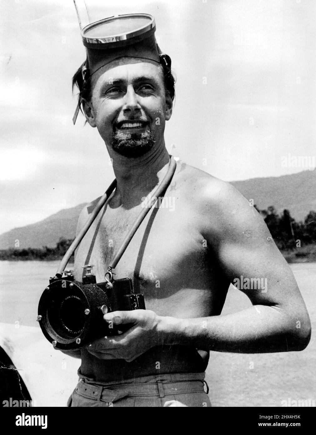 Doctor Hans Hass, Viennese underwater explorer photographed aboard the Cairns launch 'Possum' just before leaving for Ribbon Reef off Cooktown. The camera is a specially designed model for marine work and devised by himself. February 01, 1955. Stock Photo