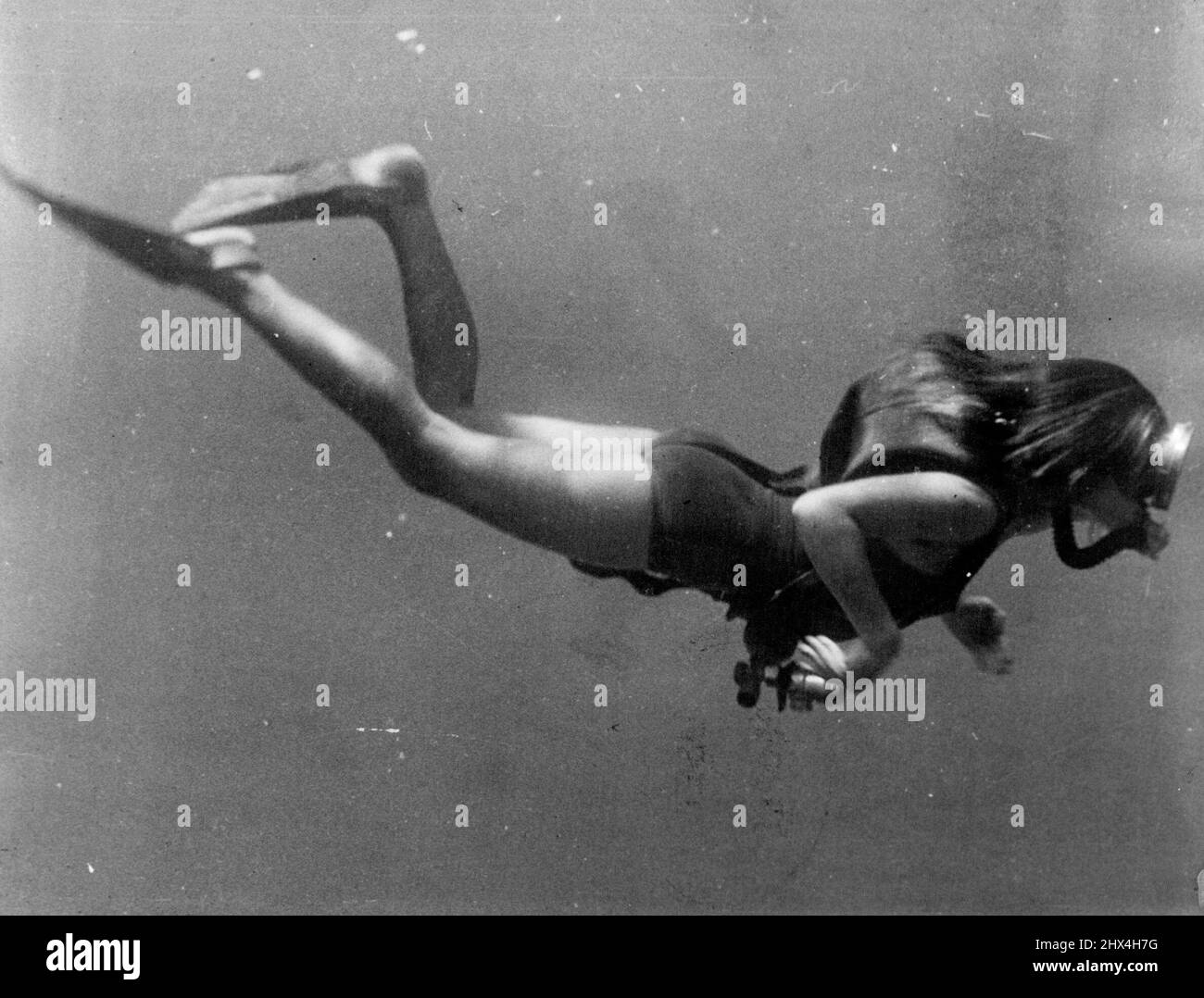 An underwater shot of shapely Lotte Hass in full diving rig. February 25, 1953. Stock Photo