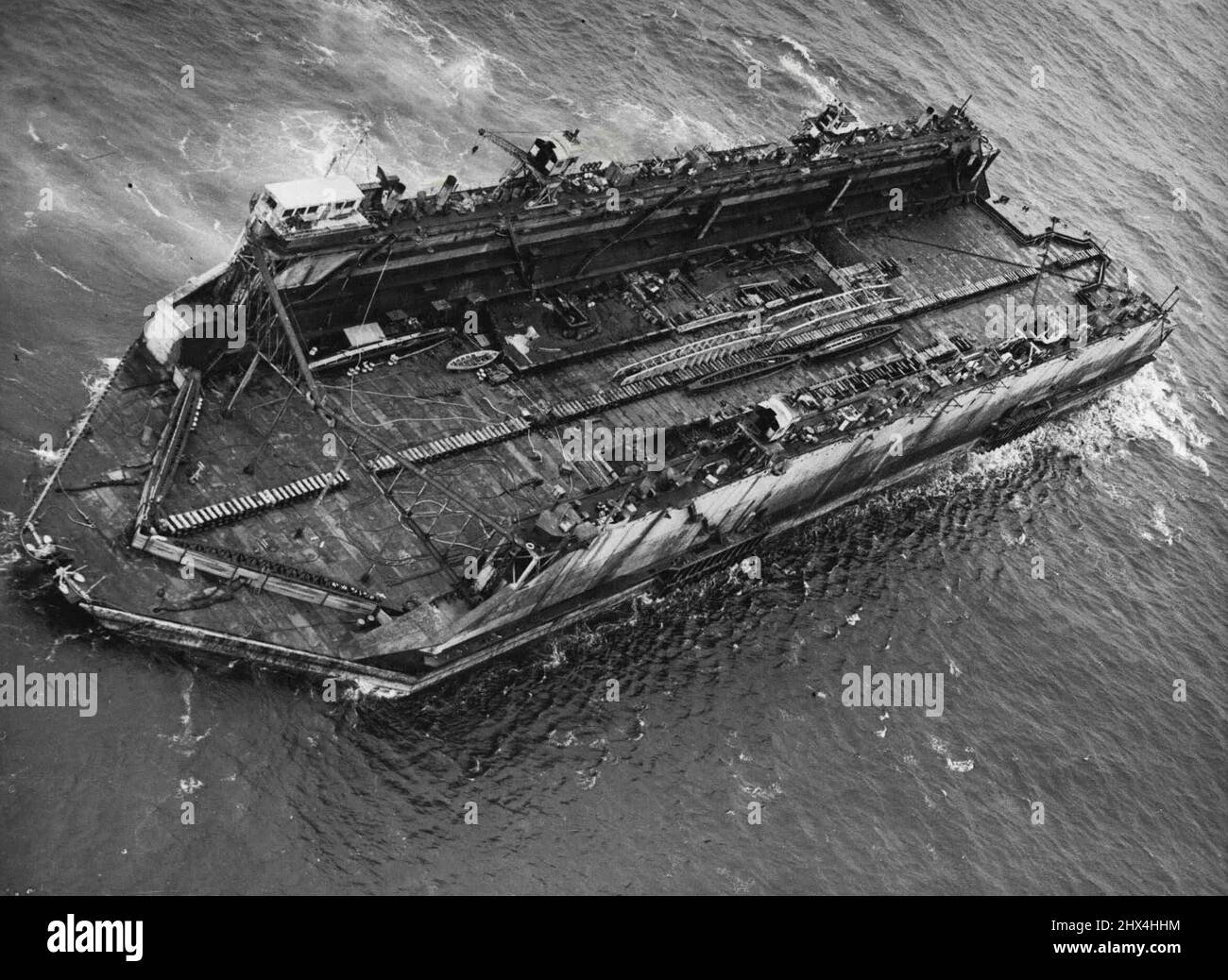 Bermuda Floating Dock Nears Britain -- Aerial view of the floating dock in the Atlantic Ocean, 400 miles off the English Coast.The largest 'Chunk' of H.M.S. Malabar, the Navy's name for its Bermuda Dockyard which was closed last March, is being brought back to Britain. Last evening, Aug. 7, it was sighted 400 miles off the English Coast, heading for Falmouth.This huge floating dock is capable of taking up to 14,000 tons of shipping at a time. Its sea trip of 2,500 miles, begun early in July, was an operation undertaken by there of the Navy's most powerful tugs, H.M. Tugs 'Reward', 'Warden' and Stock Photo