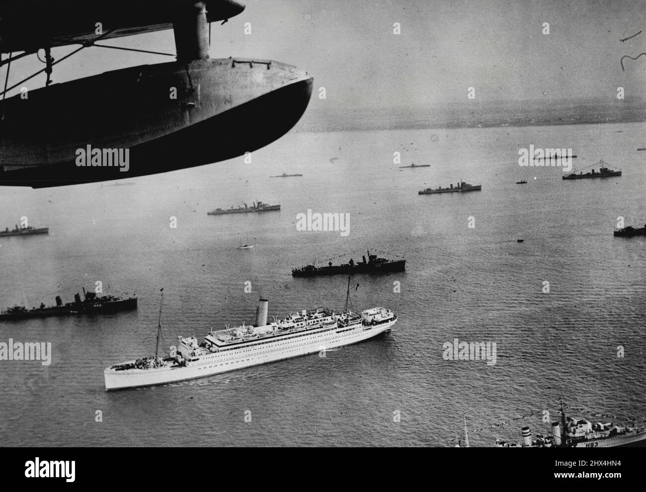 The Fleet Awaits The King's Review - A view taken from a flying-boat this morning at Spithead, off Portsmouth, showing a liner boaring guests between the lines of the mighty Fleet assembled for the Royal Review by King George VI today. May 20, 1937. (Photo by The Topical Press). Stock Photo