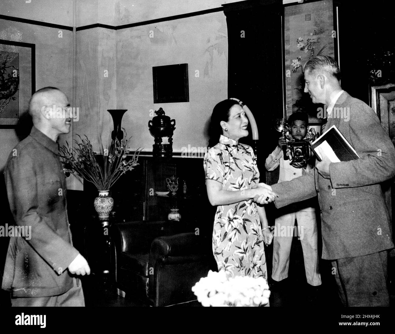 Wedemeyer Visits Chiang Kai-Sheks -- Lieut. Gen. Albert C. Wedemeyer (right) is greeted by Madame Chiang Kai-Shek during a formal visit at Nanking, China, July 23. at left is the Generalissimo. Wedemeyer is in China on a Fact-Finding mission fro press Harry S. Truman. January 12, 1950. (Photo by Associated Press Photo). Stock Photo