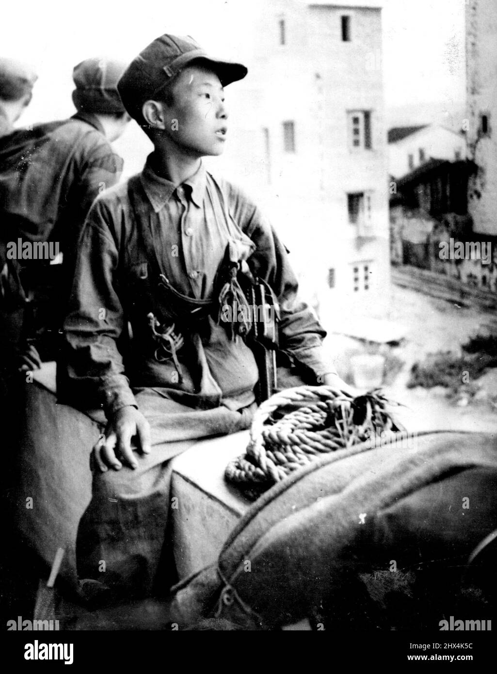 Armed Boy On Hong Kong's Border -- At an age when most boys are still playing with toy weapons, this youthful soldier of the Chinese Communist Army is serving in the garrison at Shumchun, a newly-occupied large town just north of the point where the Canton-Kowloon railway crosses the frontier into Hong Kong colonial territory Many of the Communist newcomers appear no more than 14 or 15 years of age but, like this boy, may be well armed, with pistol and grenade at the belt. October 27, 1949. (Photo by Reuterphoto). Stock Photo