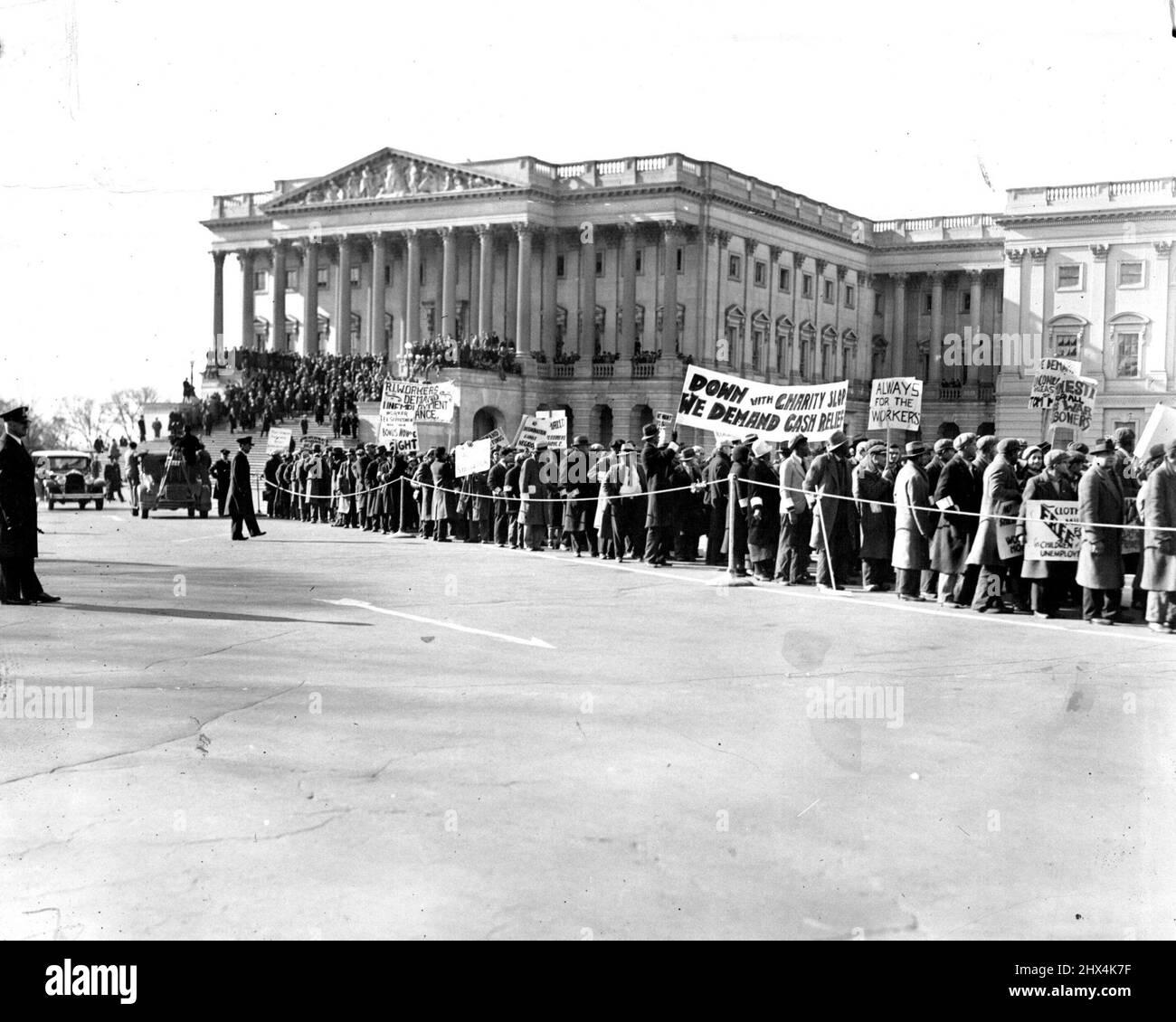 A 'Hunger' Army of Occupation -- In Washington - Some of the 1500 'Hunger' marchers assembled in capitol square today (Monday to wave their placards and demand attention from the National Government. Forcible ejected from both the senate and the house, leaders of the 'army ' and their followers proceeded to the white house to air their grievances. A riot gun squad took up its position on the capitol steps to prevent any serious disturbances. July 12, 1931. (Photo by International Newsreel Photo). Stock Photo