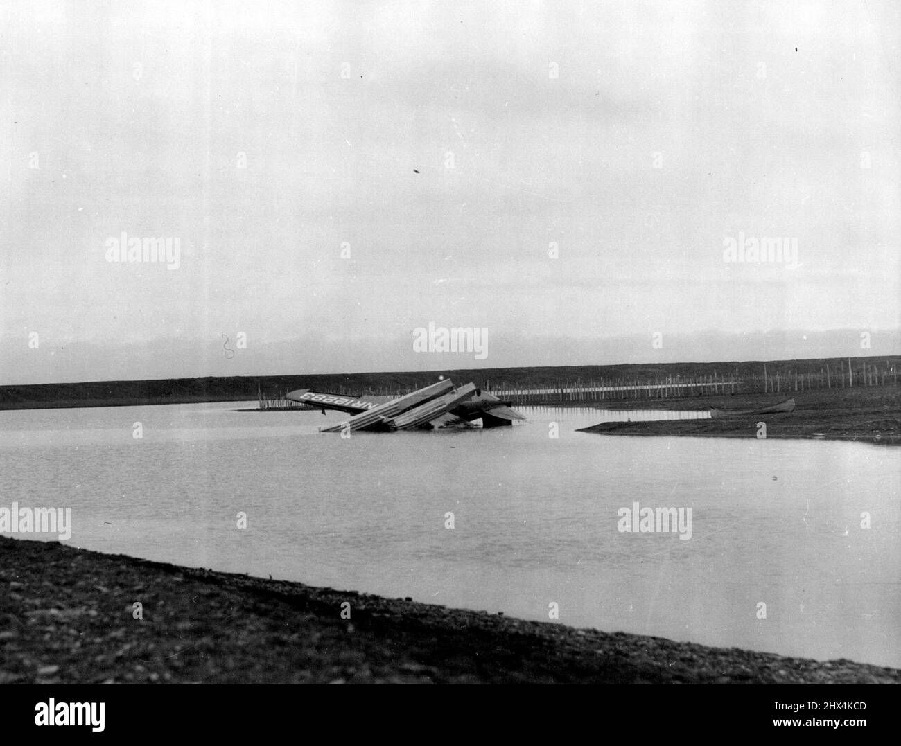 General View Of Post-Rogers Crash Scene -- This picture gives an excellent idea of the desolate Northern tundra country in which will Rogers and Wiley Post crashed fatally. The wreckage of their plane is lying in the water here it fell near the little Eskimo camp where they stopped to ask the way. August 19, 1935. (Photo by Dr. Henry Greist, Associated Press Photo). Stock Photo