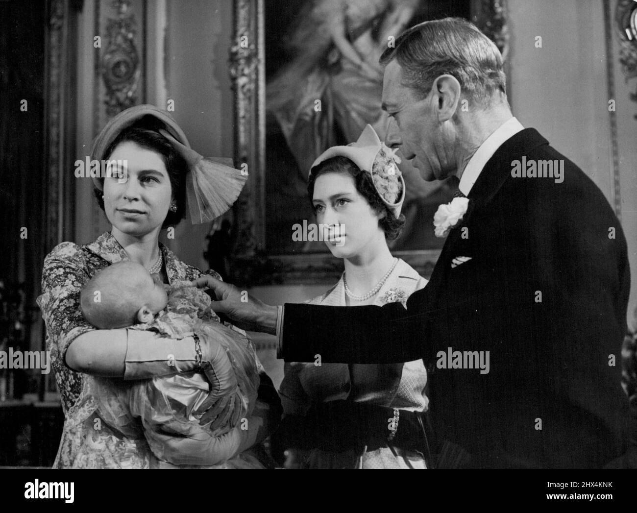 A Princess Was Christened - The King makes friends with his little granddaughter. Princess Anne (held by Princess Elizabeth). In centre is Princess Margaret. Britain's latest Royal Baby, daughter of Princess Elizabeth and the Duke of Edinburgh, was christened Princess Anne Elizabeth Alice Louise at Buckingham Palace, London, today. The little Princess, who is two months old, were the royal robe of Honiton lace handed down from Queen Victoria's days. October 21, 1950. Stock Photo