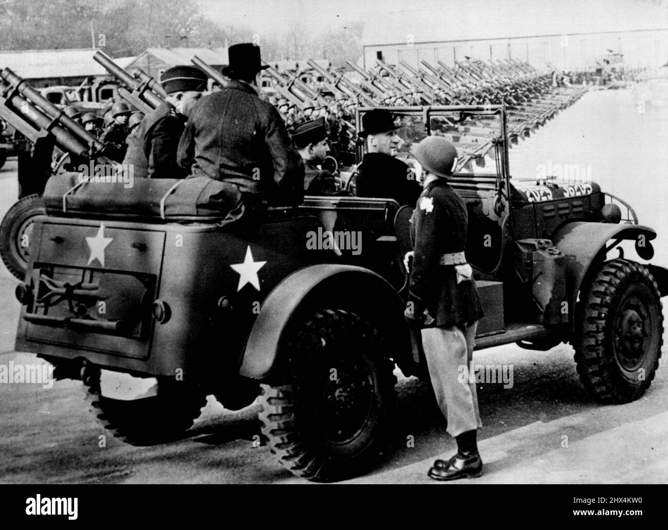 Allied Leaders Inspect Invasion Equipment - During their inspection of invasion supplies at a U.S. army depot in England, British Prime Minister Winston Churchill and U.S. Gen. Dwight D. Eisenhower, Commander in Chief of the Allied Expeditionary Force in Great British, survey a long line of howitzers from the rear seat of an American scout car. May 10, 1944. Stock Photo