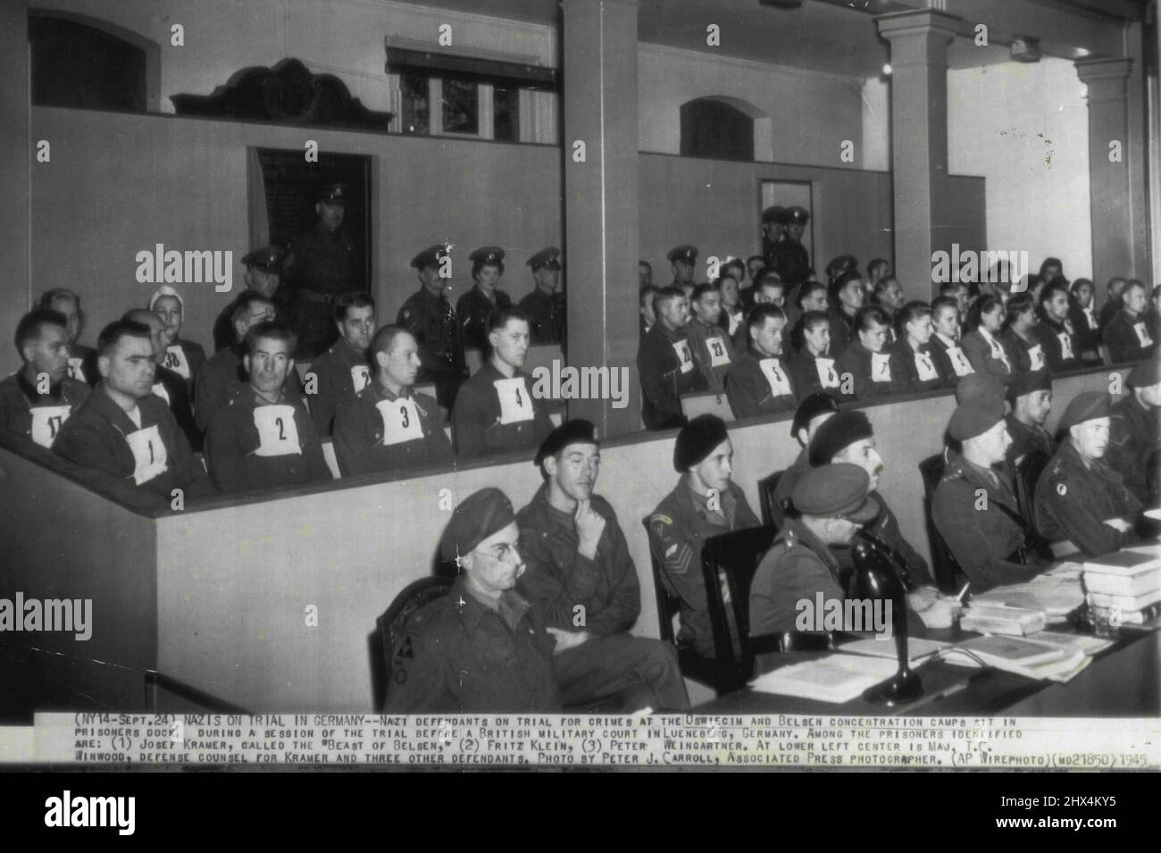 Nazis on Trial in Germany -- Nazi defendants on trial for crimes at the Oswiecin and Belsen concentration camps sit in prisoners dock during a session of the trial before a British Military court in Lueneberg, Germany. Among the prisoners identified are; (1) Josef Kramer, called the 'Beast of Belsen,' (2) Fritz Klein, (3) Peter Weingartner. At lower left center is Maj. T.C. Winwood, defense counsel for Kramer and three other defendants. September 24, 1945. (Photo by Peter J. Carroll, AP Wirephoto). Stock Photo