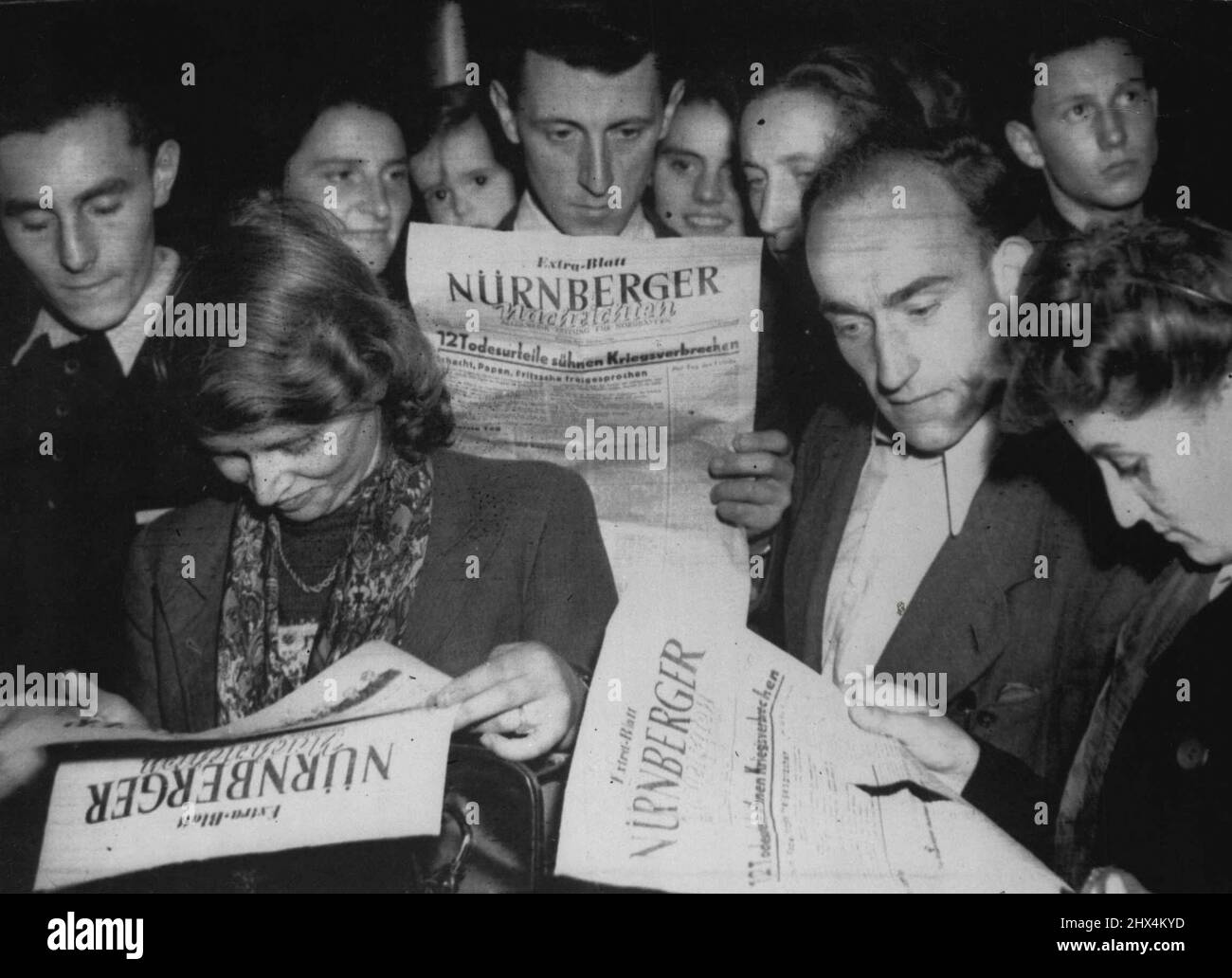 Germans Read Nuremberg Verdicts -- Citizens of Nuremberg crowd around to read the verdict of the international military tribunal in the local papers, October 1, when Hermann Goering and Eleven others of Hitler's disciples were sentenced to hang; seven sentenced to terms of imprisonment; and three acquitted and discharged. October 9, 1946. (Photo by Associated Press Photo). Stock Photo