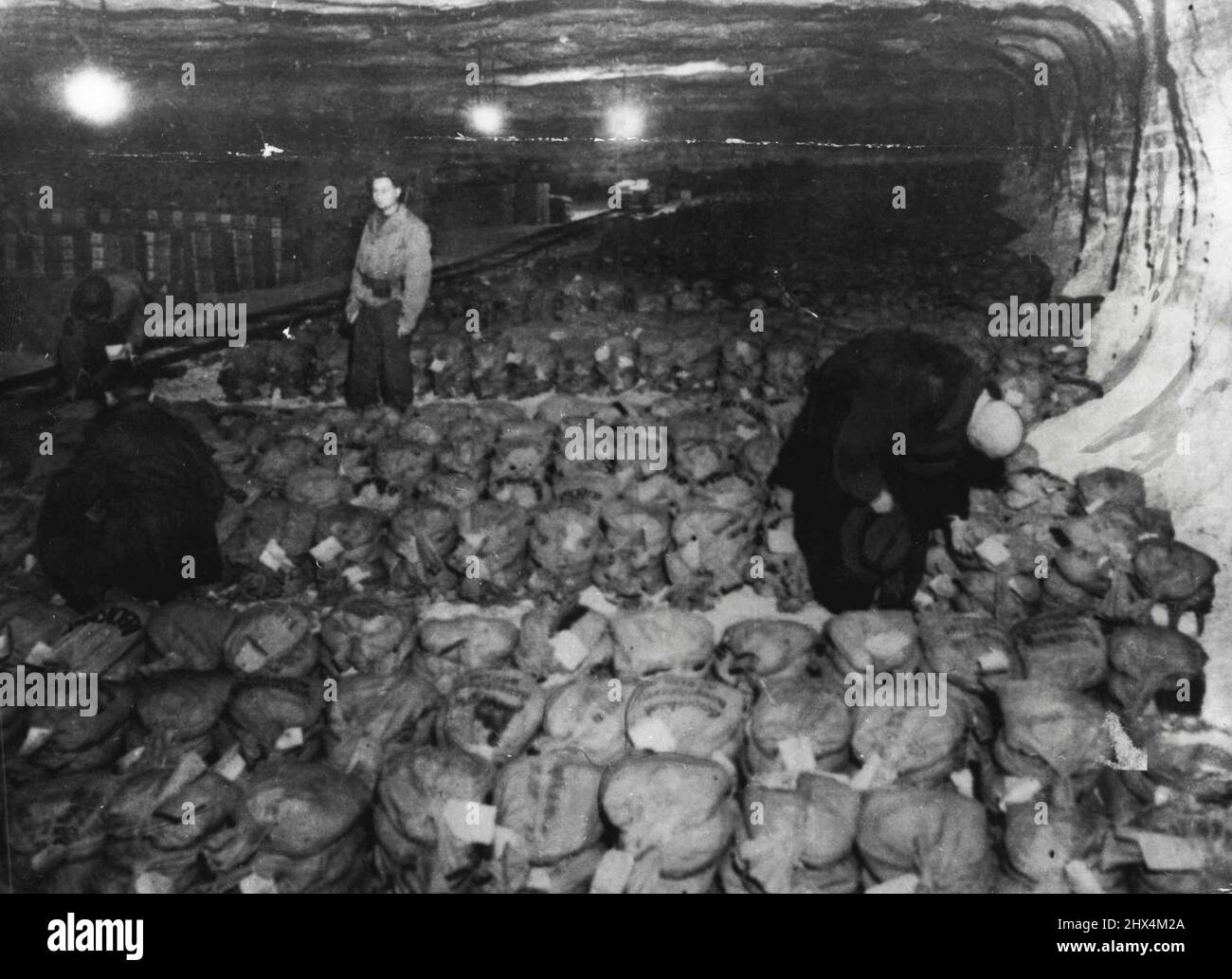 Third U.S. Army Captures Reich Gold Reserve -- A Reichsbank official (right), taken into custody along with the mine's treasures, checks over the masses of labeled bags of money with finance corps men of the Third U.S. Army.what is believed to be the entire gold reserve of the German Reichsbank, hoards of German and Allied paper currency and priceless art treasures moved from Berlin were discovered in a salt mine in Markers, Germany, by troops of the Third U.S. Army April 7, 1945. It is estimated that 100 tons of gold bullion, probably all that Germany possesses, was stored in the underground Stock Photo