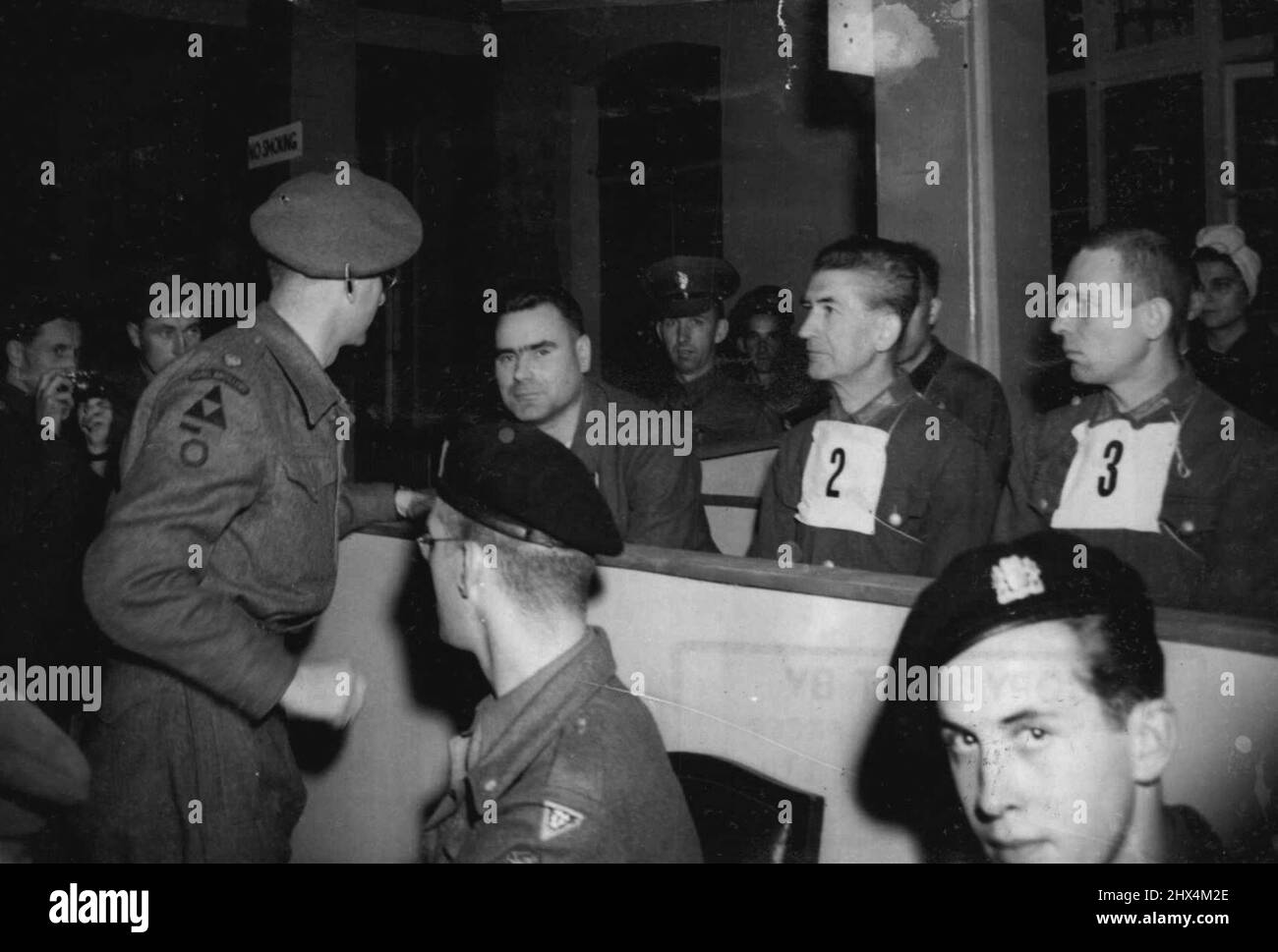 Kramer's defence council, Major T.C.M. Winwood, of reading, who was a London sclicitor before joining the army, speaks to the beast of Belsen, during the first days trial at Luneberg. The first of the war criminal trials to be held in Germany, began on September 17 at Luneburg, when Josef Kramer, 'The Beast of Belsen' took his stand in the specially prepared courtroom at Lunenburg, together with 29 men and 19 women who will also be charged with the ill-treatment of allied war prisoners. October 15, 1945. (Photo by Associated Press Photo) Stock Photo