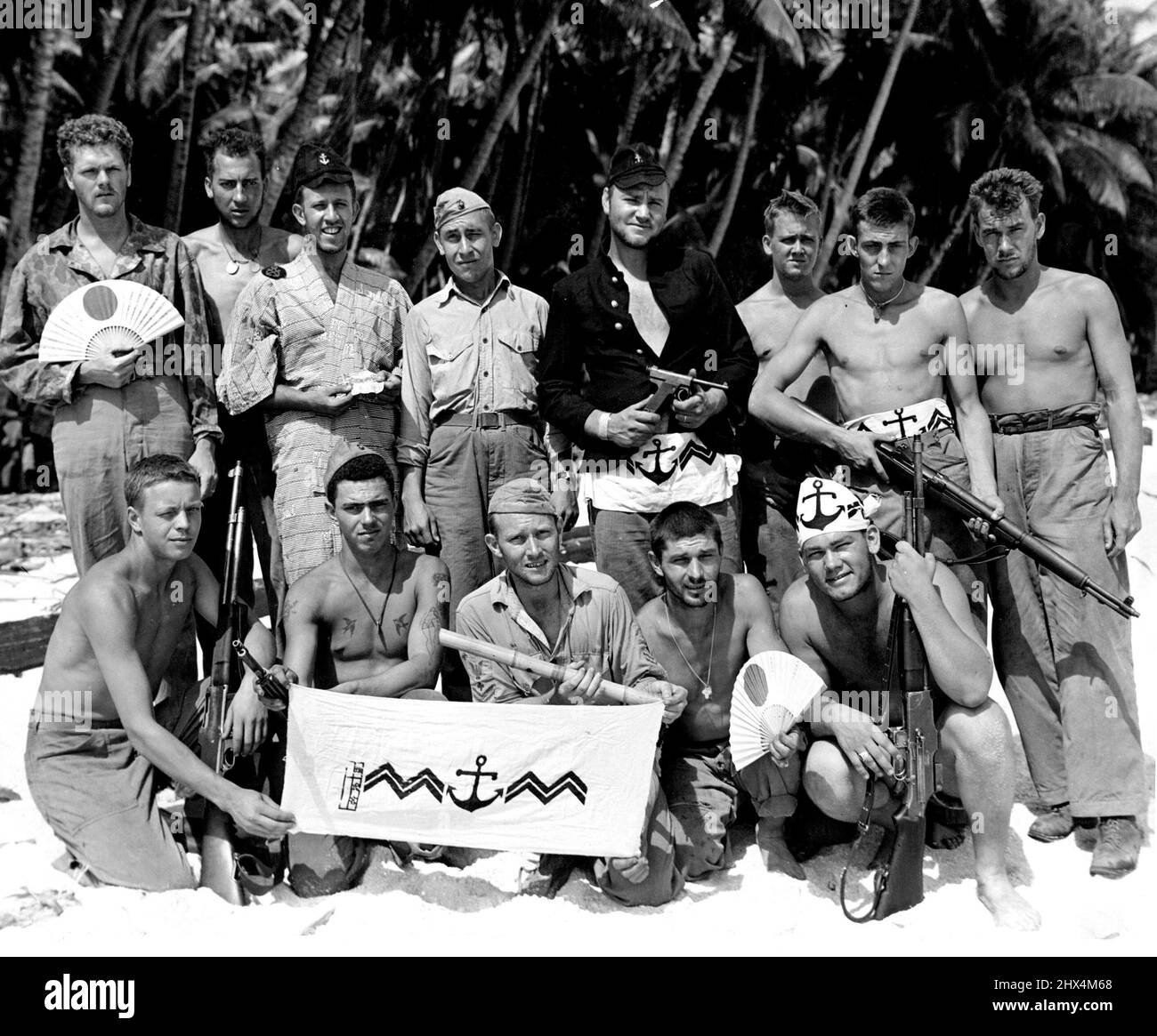 Marines With Pacific Battle TrophiesAfter having cleared Tarawa of the enemy, these Marines wear and display some of the Japanese trophies they picked up in battle. This group went to Apamama after Tarawa, left to right (standing): PFC Robert M. Phillips, Milwaukee, Wis.; Cpl. Raymond W. Boese, Bloomer, Wis.; PFC Herman Kaufman, Chicago, Ill.; Lieut. J. B. McPeters, Killen, Ala.; Sgt. Stanley V. Grooms, Everett, Mass.; PFC Peter A. Olson, Berkeley, Calif.; Pvt. Alvin G. Shulz, Lake Mills, Wis.; and Cpl. Charles F. Wolfe, Ada, Ohio. Seated: PFC Donald R. Nielson, Neenah, Wis.; Pvt. Oscar J. Str Stock Photo