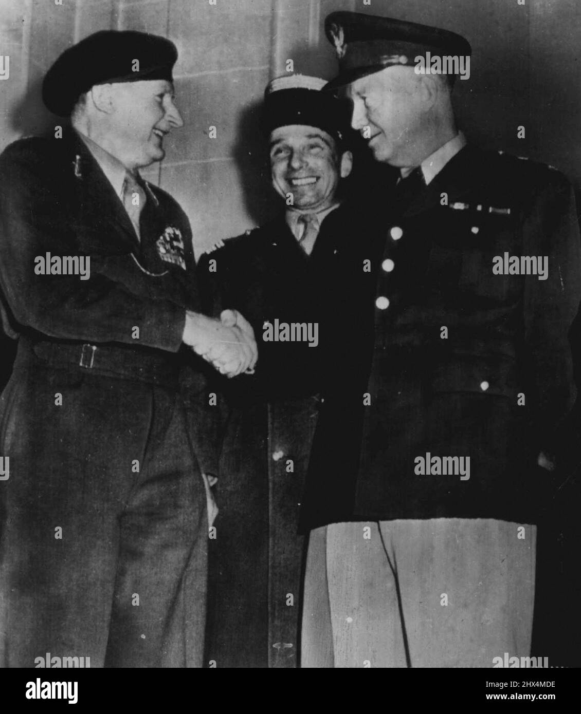 Like Old Times -- Britain's Field Marshal Lord Montgomery (left) and Gen. Dwight D. Eisenhower (right), top-ranking leaders of Allied forces in western Europe in World War II, shake hands at Hotel Raphael in Paris today following Ike's arrival to take command of North Atlantic pact nations' forces in western Europe. Monty, head of the Western Union military organization, may become one of Ike's top level associates in the defense of western Europe against Communism. In center is French Col. Costa de Beauregard, Montgomery's aide. January 7, 1951. (Photo by AP Wirephoto). Stock Photo