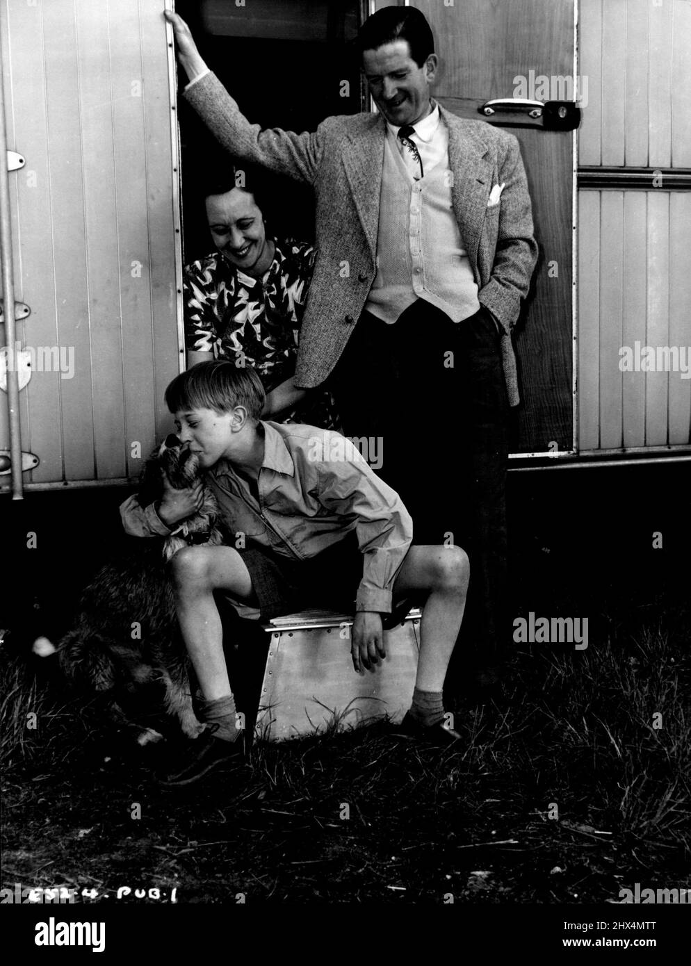 Thirteen-year-old Andrew Ray who stars with Kenneth More and Kathleen Ryan in the Associated British-Marble Arch Production 'The Yellow Balloon' with his mother and famous comedian father Ted Ray - hot forgetting Rusty - outside the family caravan which was brought to Elstree Studios for the length of the production. In the caravan Mrs. Ray Cooked her son's meals and a tutor supervised his lessons. 'The Yellow Balloon' was produced by Victor Skutezky and directed by J. Lee Thompson. September 30, 1952. Stock Photo
