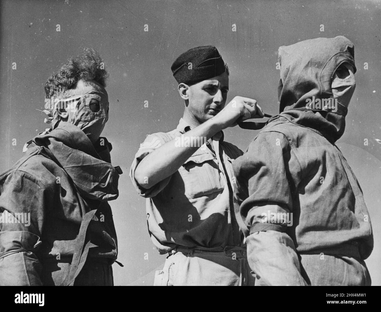 Airmen being helped on with their anti-typhus suits by a member of,the R.A.P. medical branch. The R.A.F. medical staff of the Evacuation Centres dealing with wounded partisans from Yugoslavia, wear anti-typhus suits to prevent them from picking up typhus lice inevitably carried by the partisans. The aircraft are fumigated immediately the wounded leave, and no one is allowed to enter the machines for at least 15 minutes. September 25, 1944. (Photo by British Official Photograph). Stock Photo