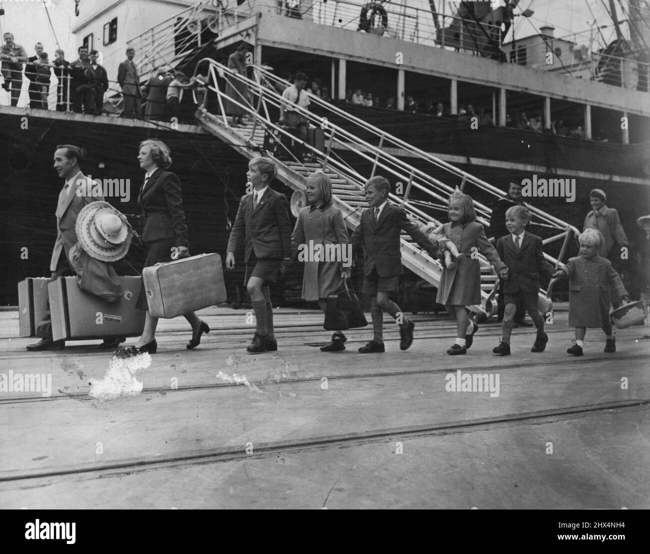 A typical British migrant family comes ashore. Migration: 'Migrants are pouring in and the work force is building up rapidly...'. Sunshine versus Vietnam? A British migrant family steps into Australia. November 17, 1955. Stock Photo