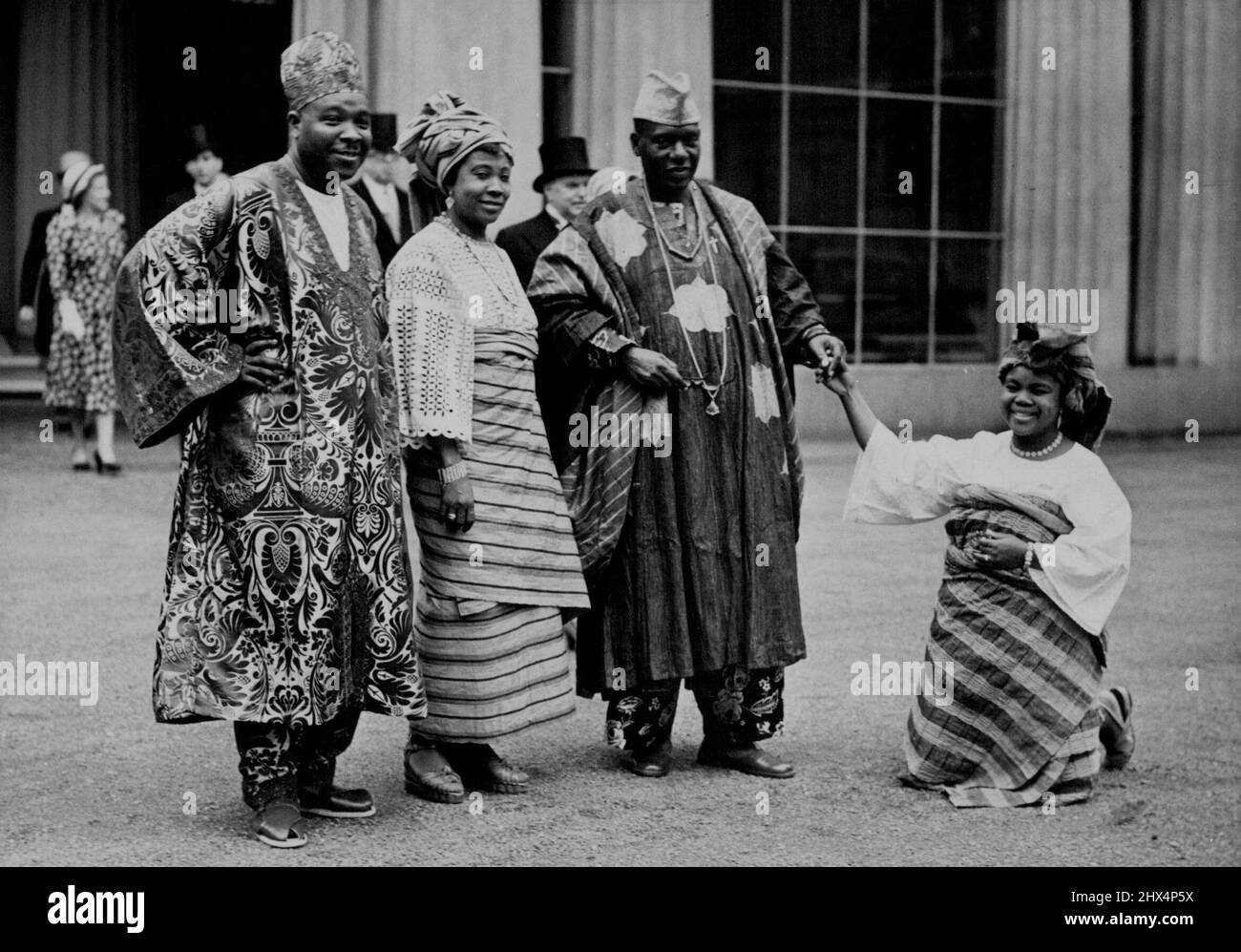 Nigerian Knighted at Palace Investiture. Photographed in the forecourt of the Palace after the investiture today. Left to right: Justice Prince Ademola, Lady Abaymoi, Sir Kofo Abayomi, and a Nigerian friend, paying her respects, Mrs. Adebiai Vincent, who is studying Social Science at Bath. H.M. the King today conferred the title of Knight Bachelor on Mr. Kofo Abayomi from Nigeria, at on Investiture held at Buckingham Palace. July 31, 1951. (Photo by Fox Photos). Stock Photo