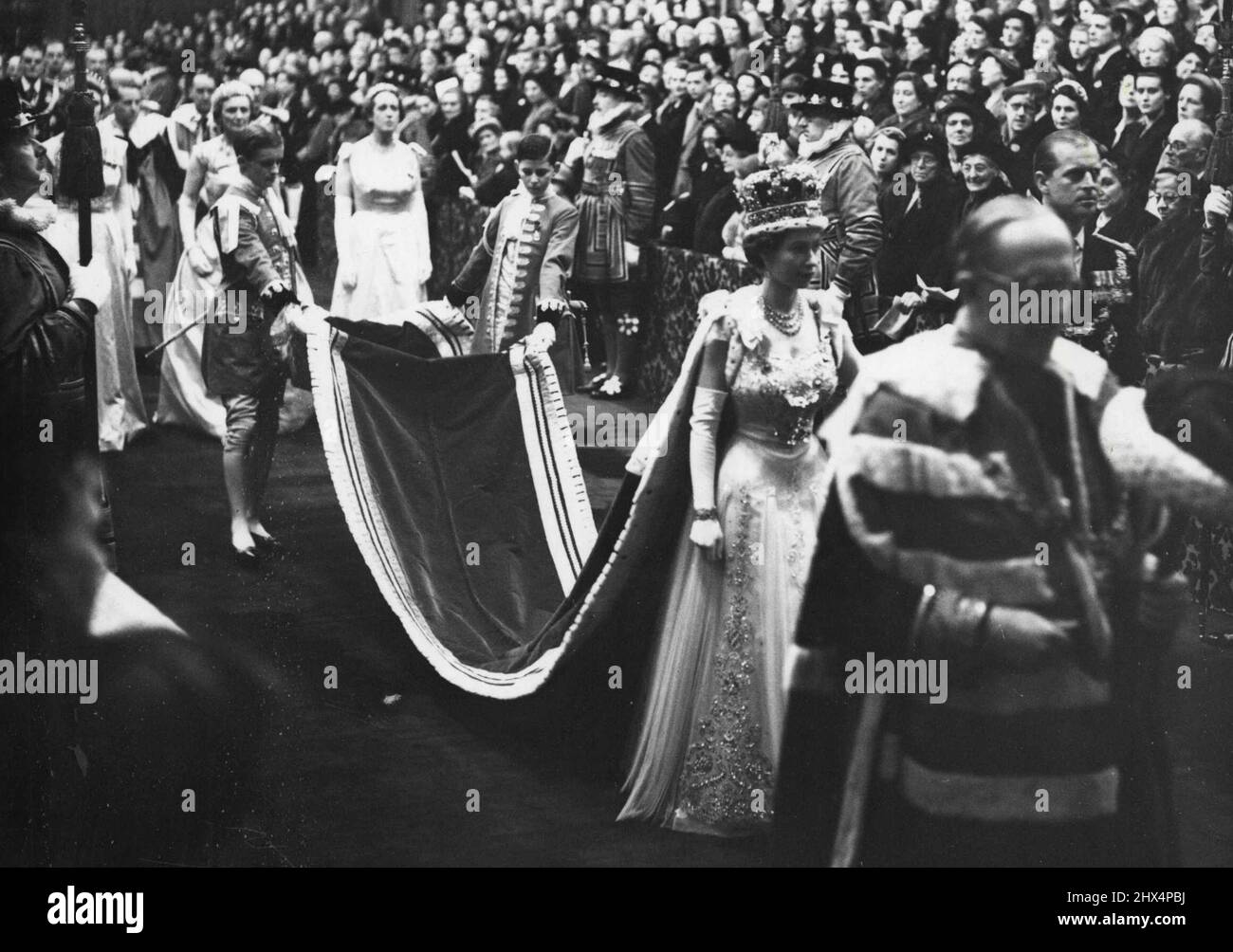 State Opening Of Parliament.The magnificent scene of pageantry as Her Majesty The Queen in her Robes and wearing the Imperial Crown, leaves the Robing Room and walks in procession through the Royal Gallery to the Chamber of the House of Lords to perform the State Opening of Parliament. Her Majesty is accompanied by H.R.H. The Duke of Edinburgh and proceeding them (extreme right) is The Marquess of Salisbury bearing the Cap of Maintenance. Her Majesty's pages are the Hon. Anthony Tryon and Edward Adeane Esq. (This is the first occasion that it has been allowed to talks a photograph of a reignin Stock Photo