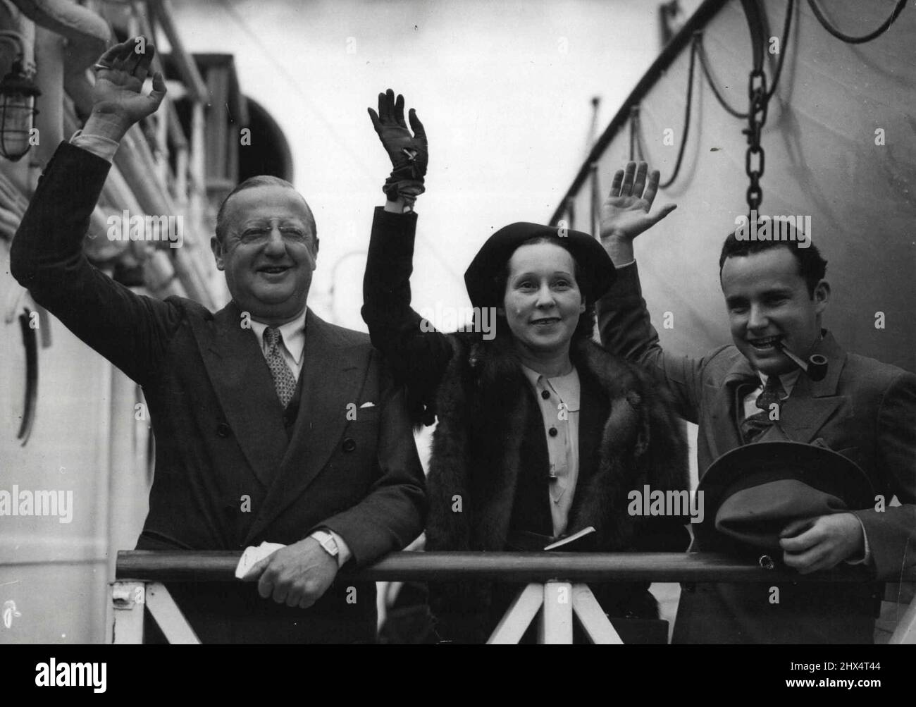 Famous Pioneer Of American Film Industry Arrives In England.Mr. Jesse Lasky, with his wife and son waving a greeting from the Empress of Australia on arrival at Southampton from Quebec today, Sept. 13.Mr. Jesse Lasky, one of the pioneers of the American film industry, who has joined Miss Mary Pickford, to form the Pickford-Lasky Film Productions Co., arrived in England on board the Empress of Australia today, Sept. 13. He is here to make arrangements for English productions for the new company, and in his first visit to England for five years. September 13, 1935. (Photo by Associated Press Pho Stock Photo