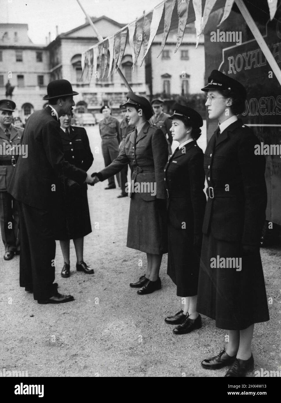 War Secretary Meets Army Recruiting Girls - Mr. Anthony Head shaking hands with Corporal Jean Douglas of Geelong, Victoria, Australia, in the new-Nursing Corps uniform; center is Corporal Joan Gallagher of Co. Durhom, and nearest camera is Private F. Monkman of Scarborough-both are wearing the new W.R.A. C. No. 1 uniform. The Army's new mobile exhibition for the Women's Royal Army Corps and the queen Alexandra's Royal Army Nursing Corps was inspected by Mr. Antony Head, the Secretary of State for War, on the Horse Guards Parade, London, to-day (Tuesday). July 8, 1952. (Photo by Reuterphoto). Stock Photo
