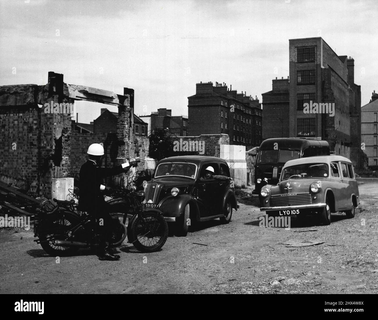 The Mobile First Aid Unit -- Trained in Peacetime the Mobile First Aid Unit is Ready for any emergency. On their way to the site of the incident the vehicles find their way blocked by debris. The Despatch Rider, who has consulted the police, returns to point out the best route to the rendezvous point. May 12, 1952. (Photo by Central Office Of Information Photograph). Stock Photo