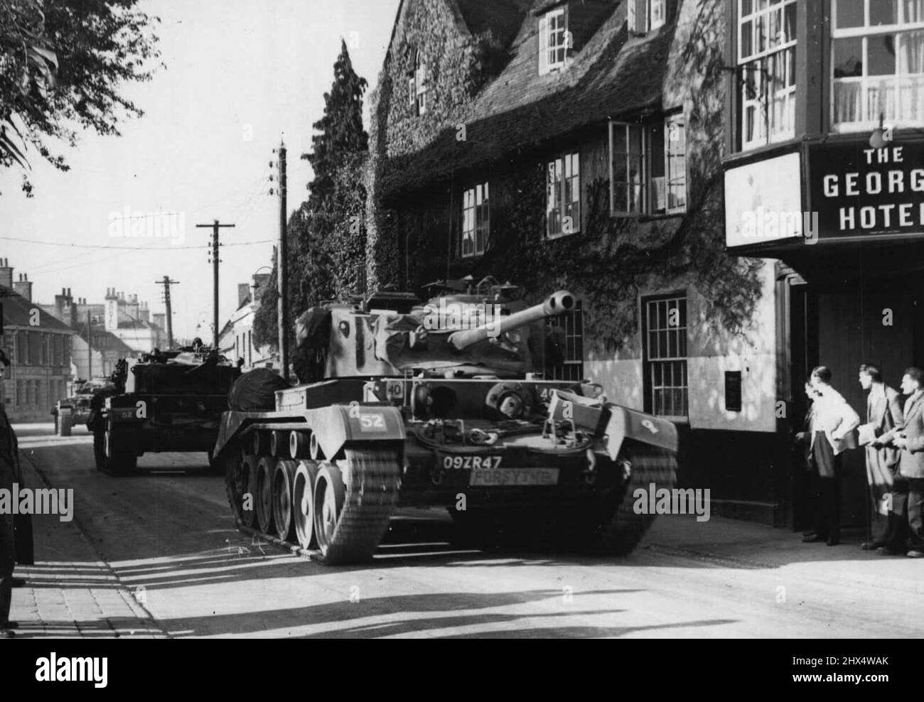 Britain's Biggest Army Maneuvers Start in Southern England -- Tanks of the 5th, Tank Regiment of the 6th. Armored Division, passing through a typical English village of Amesbury, to take up positions in the northern part of the area. Exercise 'surprise Packet' - the biggest Army maneuvers to be held in Britain is taking place over eight counties of Southern England involving some 50, 000 troops. The exercise will last for four days. October 13, 1951. (Photo by Sport & General Press Agency, Limited). Stock Photo