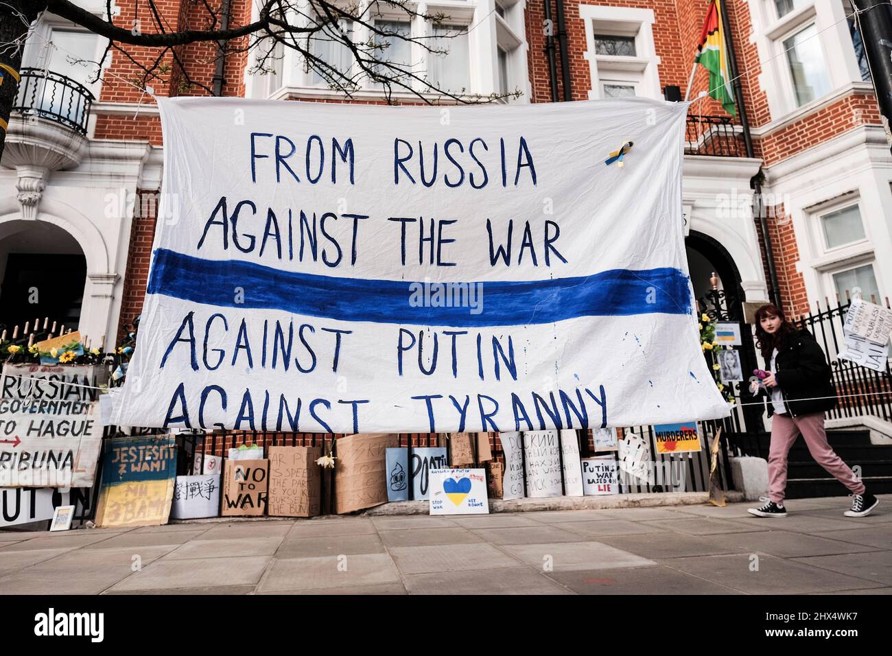London UK, 9th March 2022. A banner declaring opposition to the war from Russian citizens is displayed opposite the Russian Embassy. The Russians Against War movement has adopted a white and blue flag as a symbol of their protest.The flag replaces the red stripe of the Russian flag to remove the association with blood and violence, along with military power and authoritarianism. It also references the historic flag of Veliky Novgorod, where the government of the Novgorod Republic had a reputation for developing democratic governance. Stock Photo