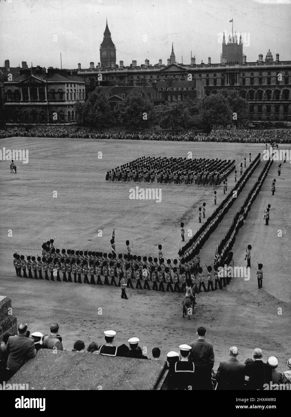 Trooping Rehearsal -- A scene on the Horse Guards Parade this morning during the dress rehearsal for the Trooping the Colour ceremony which is to take place next Thursday, the Queen's official birthday. Sailors watch the Guards troop the Colour from the roof of the Admiralty 'Citadel'. May 30, 1952. Stock Photo