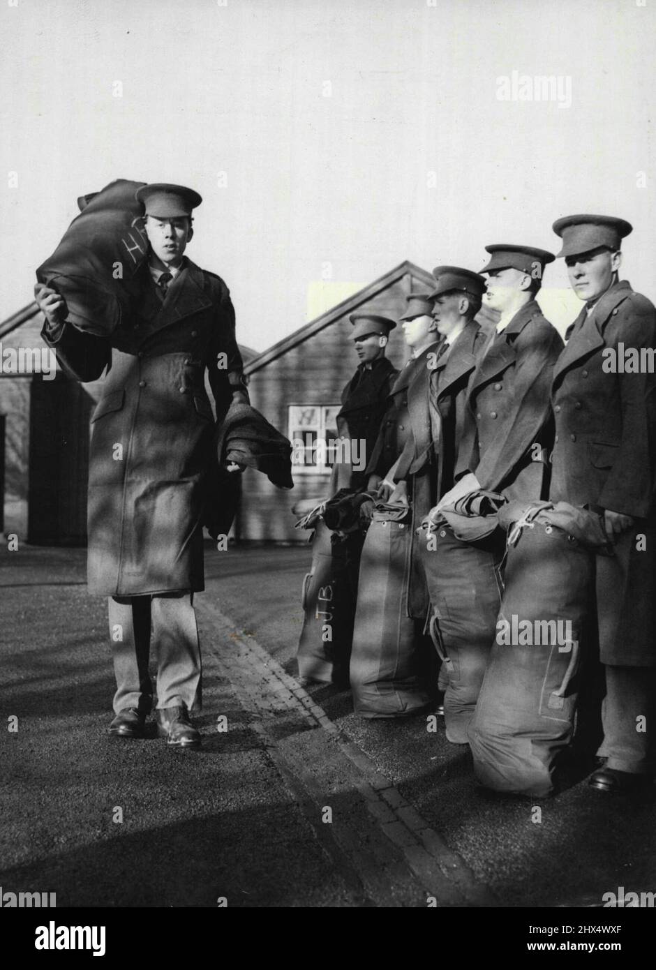 Tall - But They Have To Believe It -- Harry Readings, tallest of them all, passes other recruits at the Kitting-out parade to-day. The Army's supply line was long drawn-out to-day (Wednesday), when 18-year-old recruit Harry Readings attended a kitting-out parade at the Guards Depot, Caterham, Surrey. For Harry, formerly a gas fitter of Brookside, Ascot, Berkshire, is 6ft. 8½in. tall, weights over 14 stone and takes size 13 in footware. Further problem for the military outfitters - Harry is still growing. December 1, 1954. (Photo by Reuterphoto). Stock Photo