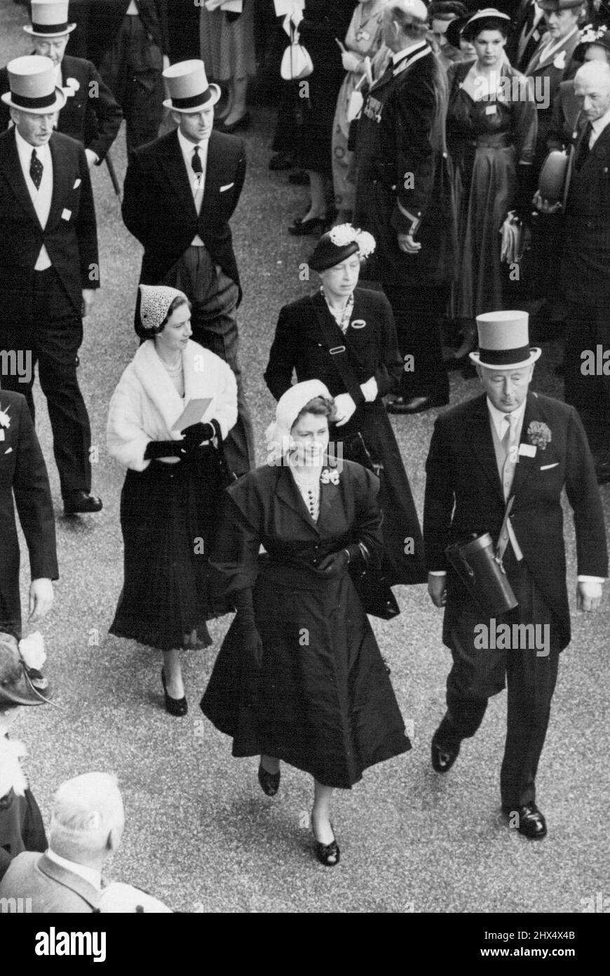 The Royal Ascot Meeting -- Walking to the Paddock at the royal Ascot race meeting. H.M. Queen Elizabeth leading with the Duke of Norfolk, followed by Princess Margaret (left) with the Princess Royal, and the Duke of Edinburgh (right) with Captain C. Moore, the Royal racing manager. June 19, 1952. (Photo by Sport & General Press Agency, Limited). Stock Photo