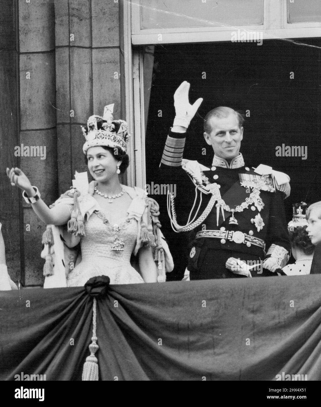 Her Happiest Day - One of the happiest picture of a happy day - the Queen, wearing the Imperial State Crown, and the Duke Edinburgh, in uniform of Admiral of the Fleet, smile and wave. From the balcony to the milling crowds pressing around the gates of Buckingham Palace after the coronation to-day (Tuesday). June 02, 1953. (Photo by Reuterphoto). Stock Photo
