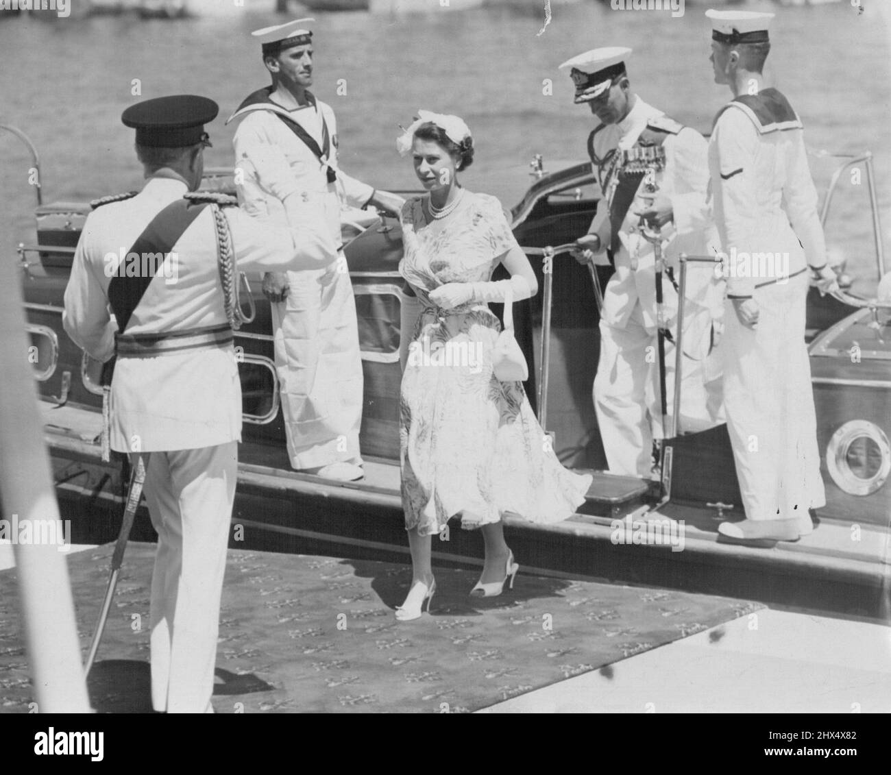 The Queen Steps Ashore -- The historic moment at Farm Cove when Queen Elizabeth II, followed by the Duke, leaves the barge to the salute of the Governor-General, Sir William Slim and the cheers of citizens who had awaited this moment for hours. February 15, 1954. Stock Photo