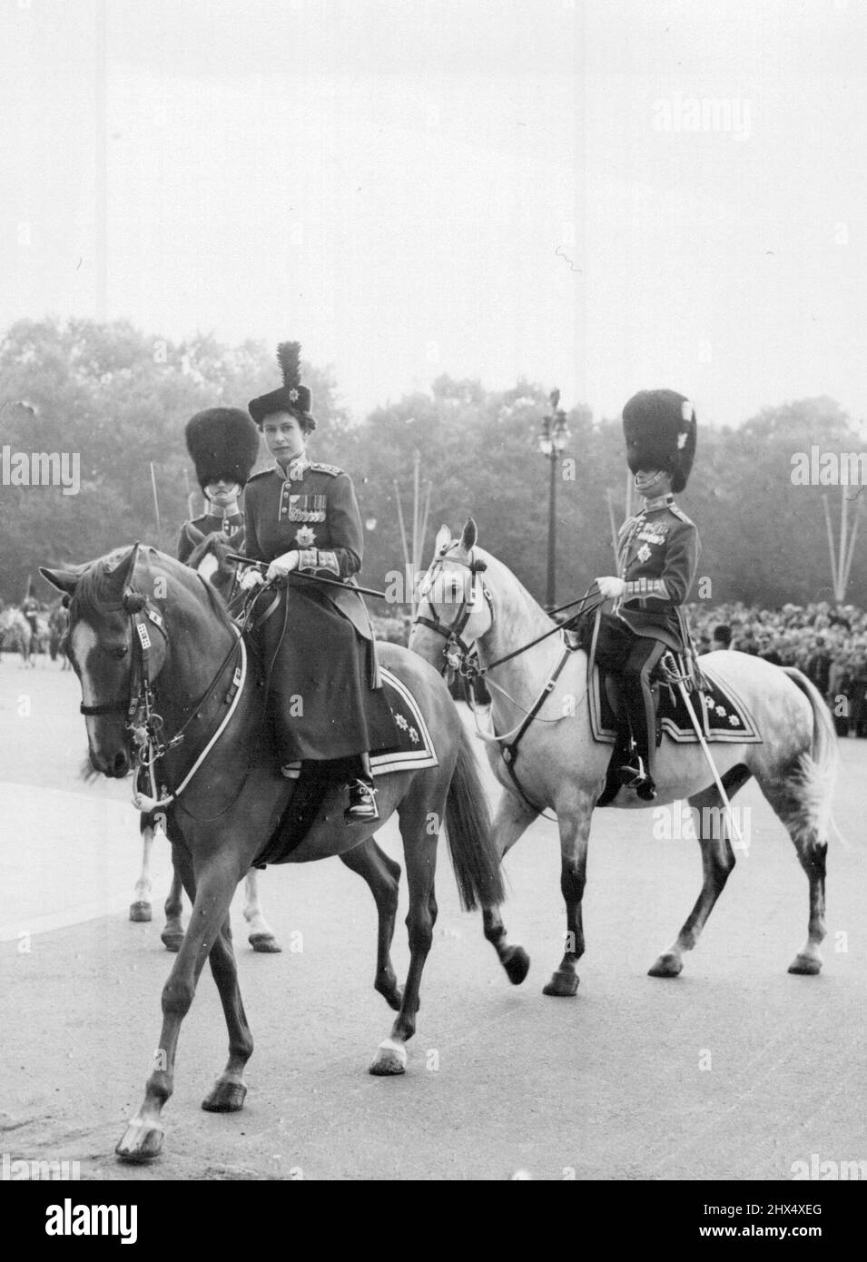 Queen And Duke After Trooping Ceremony - Queen Elizabeth, wearing the uniform as Colonel-in-chief, Goldstream guards and riding side-saddle, is accompanied by the Duke of Edinburgh (right), as she arrives back at Buckingham palace following the Trooping the Colour ceremony on horse guards parade. The Duke who is 33 today, wears the uniform of Colonel of the Welsh guards. June 10, 1954. (Photo by United Press Photo). Stock Photo
