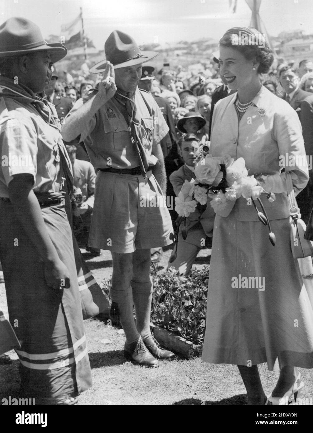 Queen Elizabeth greeting Samoan Scouts who were in the South Island for a jamboree. This picture was taken at Timaru, NZ. Colourful Dress - Scouts from Samoa, who were attending a jamboree near Timaru, will recall for many years the day they met the Queen. The scoutmaster salutes as Her Majesty talked to one of the scouts, whose colorful dress impresses the Queen. February 03, 1954. Stock Photo