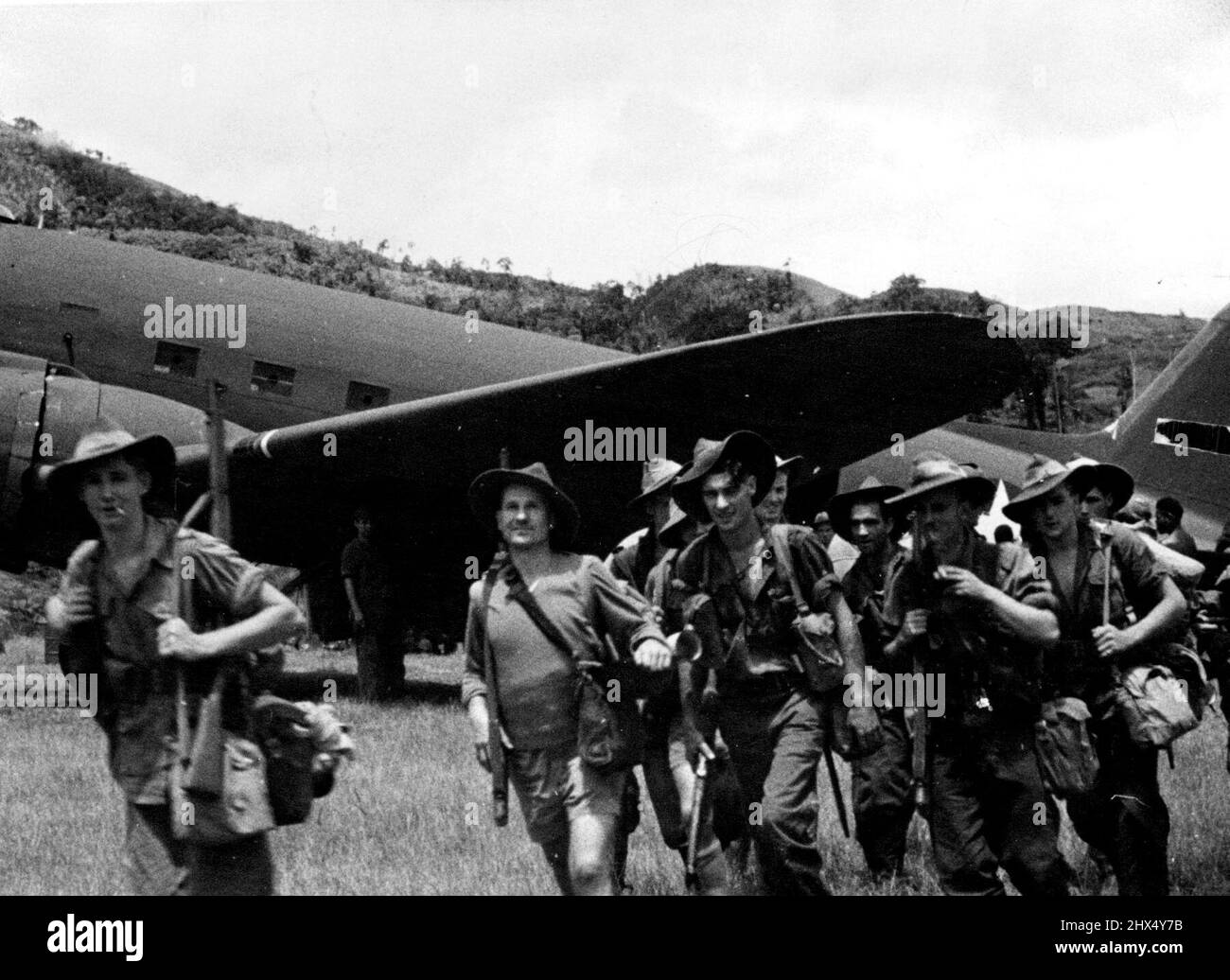 Japanese Unsuccessfully Attack Wau. Allied planes fly in troops in troops for the advance on Wau. Picture shows Australians leaving the planes on the aerodrome. These men went straight into action. February 25, 1943. Stock Photo