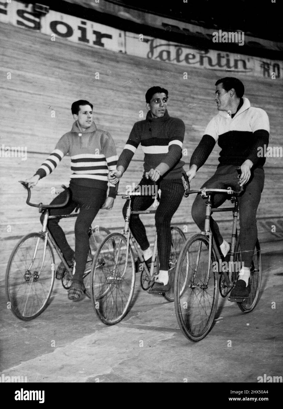 Six-Day Cycle Race In Paris -- Left to Right ; Alfred Strom of Australia; Gerit Peters of Haarlem, Holland, and Armin Von Buren of Zurich, Switzerland, make a leisurely turn around the Velodrome D'hiver, Mar. 18 in the six day cycle race in Paris, France. Australian cyclist Alf Strom (left) takes a leisurely turn around the Velodrome D'hiver during the recent six-day in Paris. Strom's companions are Gerit Peters (Holland) and Armin von Buren (Switzerland). March 20, 1950. (Photo by Associated Press Photo). Stock Photo