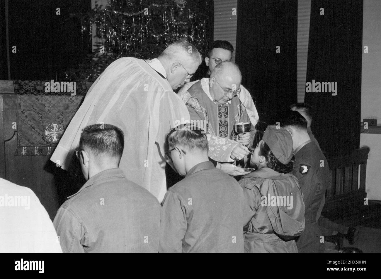 Lt. Pamela Robinson Opelousas, LA (2nd from right) receives holy communion from his eminence Francis Cardinal Spellman during mass celebration at the finance building Chapel, Tokyo, Japan. January 02, 1953. (Photo by Donald E. Wilson, U.S. Army Photo). Stock Photo