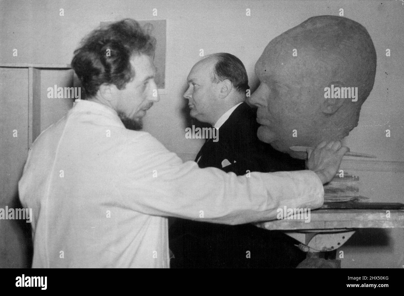 M. Spaak, First President Of U.N.O. Assembly-Poses For Sculptor In London -- M. P.H. Spaak, posing for Mr. Olam Nemon, who is putting the finishing touch to the clay model of the bust which will be carved in stone-in the sculptor's studio in Kensington, London.M. P.H. Spaak, first President of the United Nations Assembly and Belgian Foreign Minister, has been posing  Mr. Olam Nemon the Yugoslav sculptor, who is to crave a bust of the statement in stone. Most of the sittings, which are given in the sculptor's Kensington studio, have to take place at right, when M. Spaak has finished his work in Stock Photo