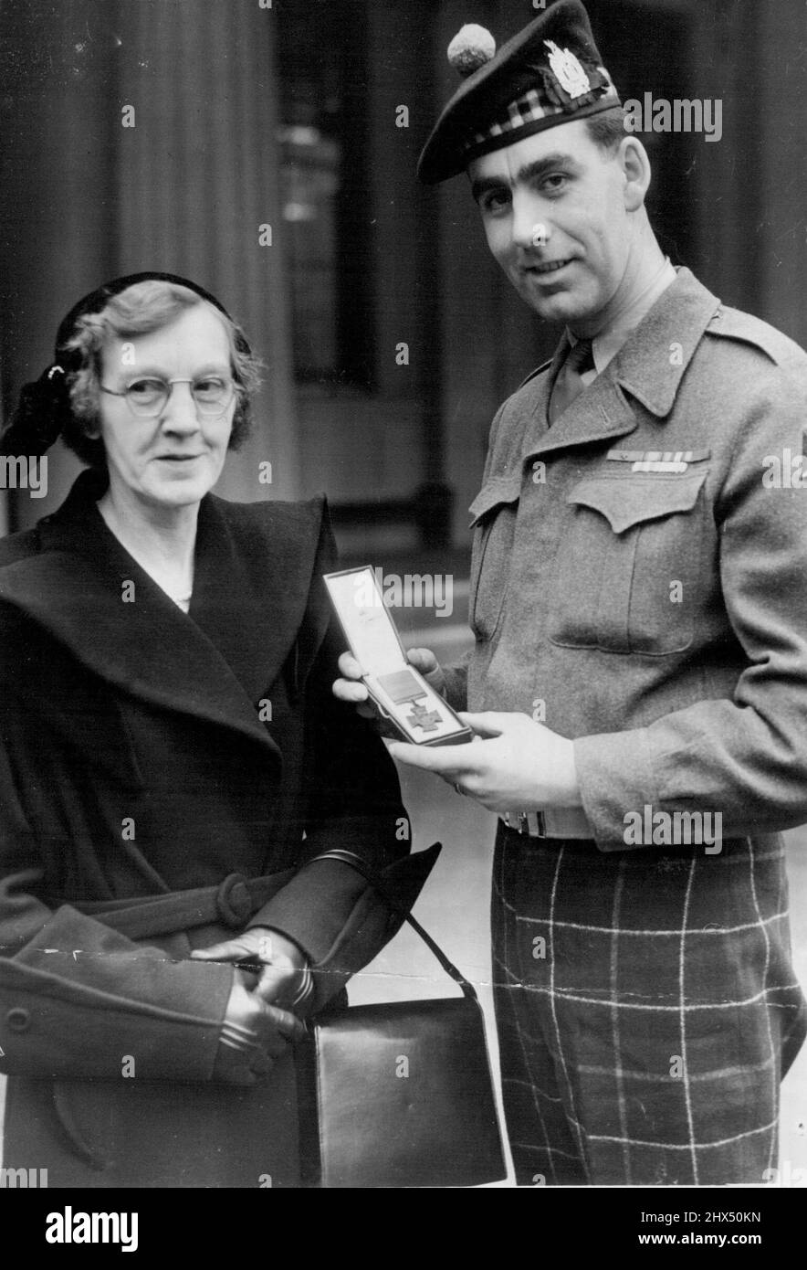 Proudest Mother of All Speakman Presented With V.C. At Palace -- A proud Bill Speakman of the Black Watch shows his mother the Victoria Cross presented to him when the Queen held her first Investiture at Buckingham Palace to-day. The 24-year-old solider of Altrincham, Cheshire, won the decoration in Korea. February 27, 1952. Stock Photo