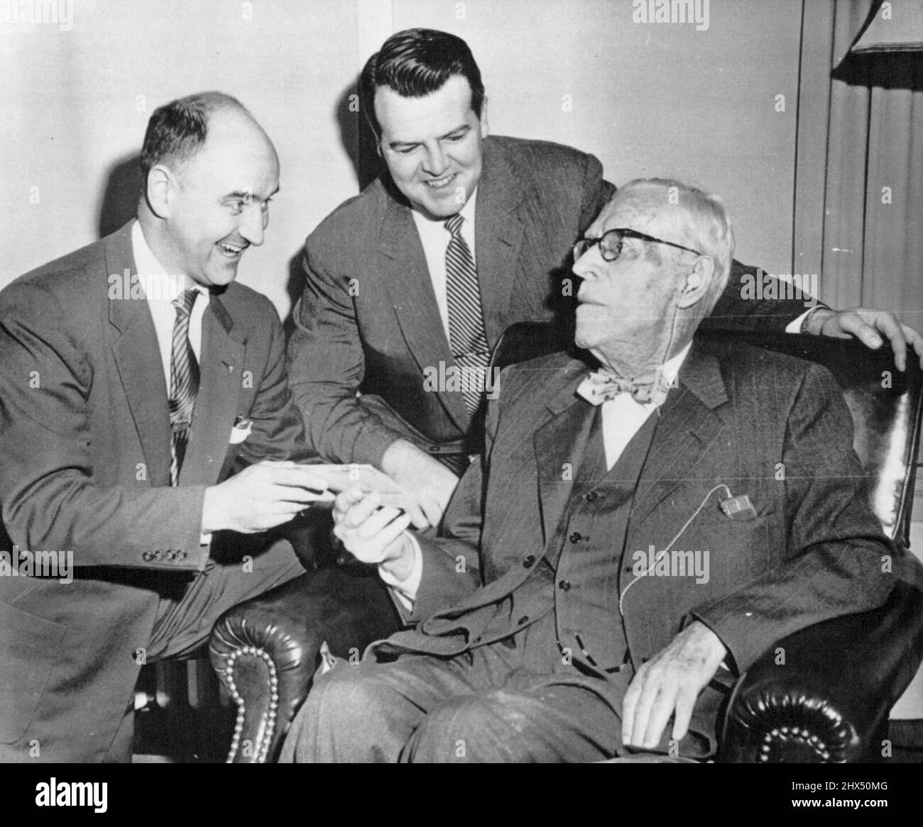 Outlives Insurance Policy -- William S. Spellman, seated, father of Francis Cardinal Spellman, receives a check representing full payment on his life insurance policy from Edward Livingston (left) and Charles H. Kerrigan, Union Central Life Insurance Co., representatives, here today. Insurance officials said the 96-year-old man has outlived the policy which happens only one time in 100,000. The amount of the check is several thousand dollars. November 15, 1954. (Photo by AP Wirephoto). Stock Photo