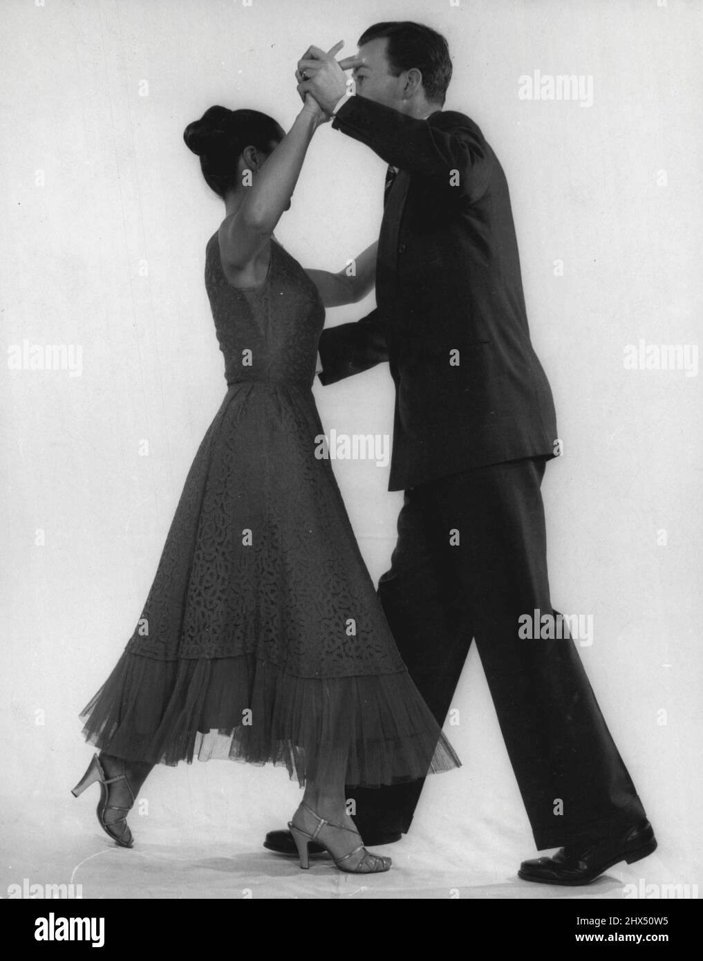 First Step -- Man moves forward with his right foot. Girl moves left foot back. (Each step counts as slow step, i.e. two beats). April 25, 1955. Stock Photo