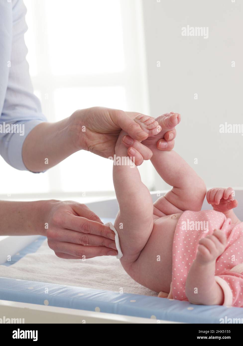 Wiping a baby girl's bottom with a cotton pad Stock Photo Alamy