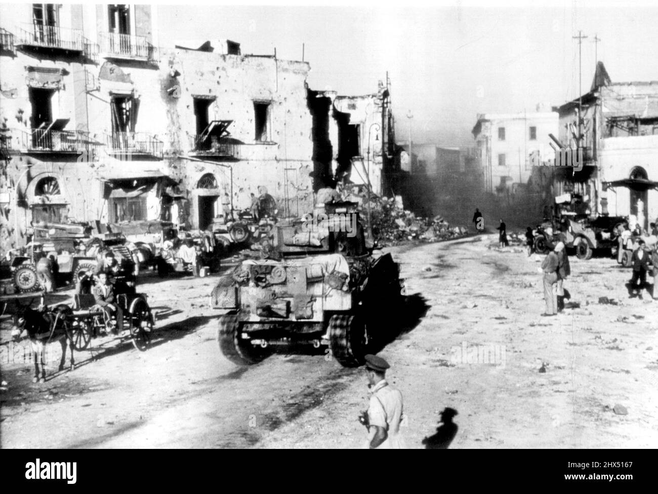 Tank Moves Though Torre Annunziata -- A British tank moves forward though the battered square of Torre Annuziata, Italy, during the advance toward Naples. October 11, 1943. (Photo by AP Wirephoto). Stock Photo