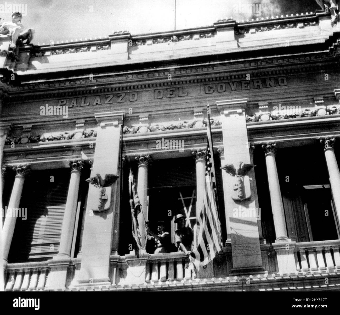 Allied Flags On Reggio Balcony -- British troops raise the stars and stripes and the union jack on the Balcony of the Palazzo Del Governo in Reggio Calabria as the Allied administration staff takes over the Italian Mainland city. This is a British Official photo. September 22, 1943. (Photo by AP Wirephoto). Stock Photo
