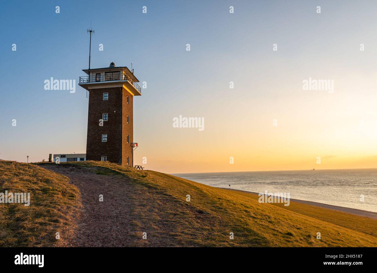 Historical coast guard tower in dutch village Huisduinen by sunset Stock Photo